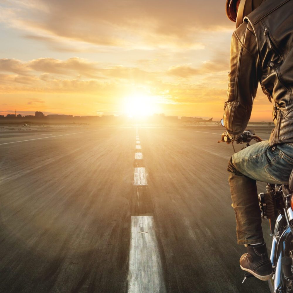 Motorcycle driver riding alone on asphalt motorway. Outdoor photography. Travel and sport, speed and freedom concept